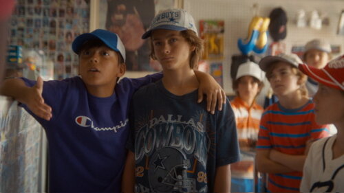Children hanging out in a room adorned with posters.